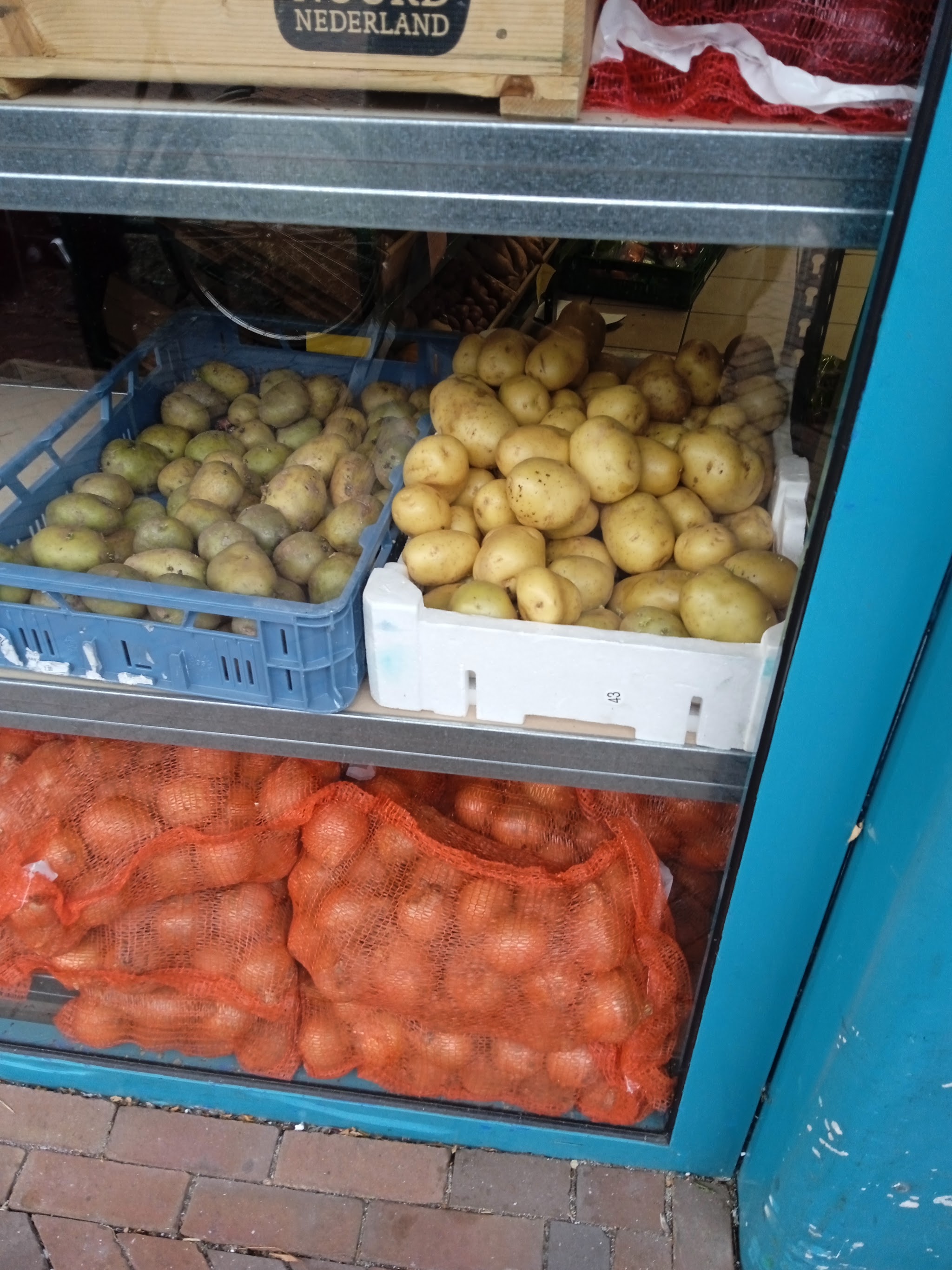 Aardappelen en uien in kratten voor de winkel